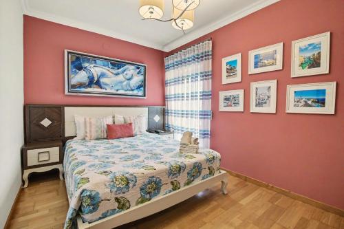 a bedroom with a bed and a red wall at Brisa Do Mar Moura Beach in Quarteira