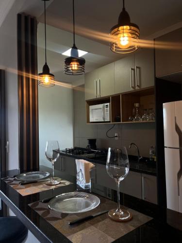 a kitchen with two wine glasses on a counter at Seu espaço in Sorocaba