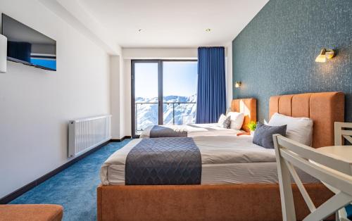 a hotel room with a bed and a large window at New Gudauri Twins Horizon in Gudauri