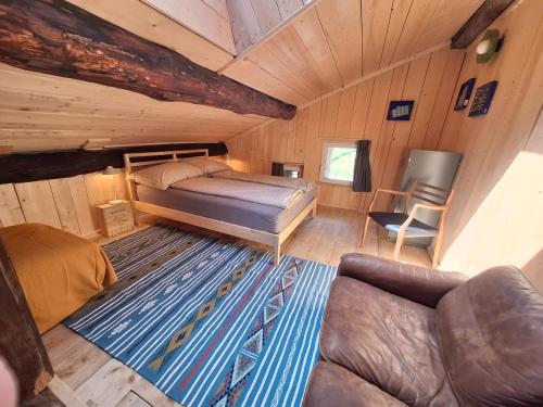 a bedroom with a bed and a couch in a cabin at Casa Piazzo Due in Brusio