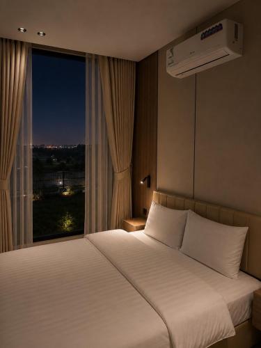 a bedroom with a large white bed with a window at Al Badr Villas Resort in Sawdāʼ