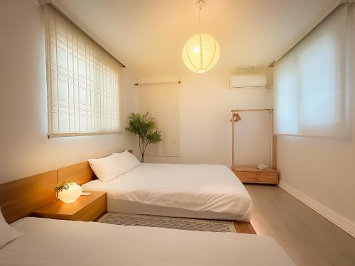 a bedroom with two beds and a potted plant at Seongsu#3beds#10min seongsu station#2min walk from yongdap station line2 #local food hot spot#DDP#KSPO in Seoul