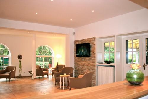 uma sala de estar com cadeiras e uma lareira em Landhaus Gut Halte em Papenburg