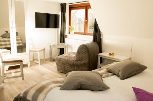 a hotel room with a bed and a chair at Landgasthof Kasch - Hotel und Restaurant in Timmdorf
