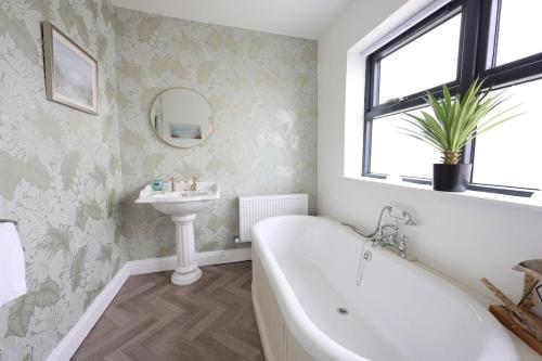 a bathroom with a tub and a sink at Harbour View - Sleeps 26 guests in Liscannor