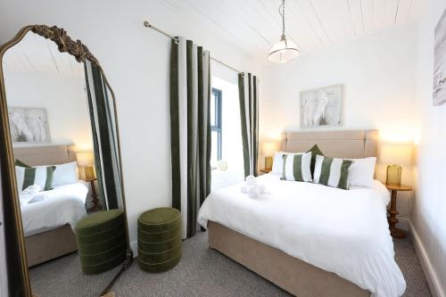 a bedroom with two beds and a mirror at Harbour View - Sleeps 26 guests in Liscannor