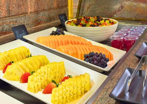 a buffet with three plates of food on a table at Dayrell Hotel e Centro de Convenções in Belo Horizonte