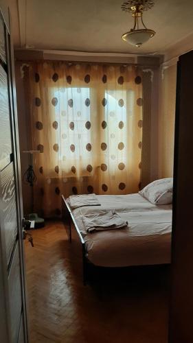 a bedroom with a bed and a window with a curtain at Saraharth in Alaverdi