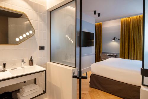 a hotel room with a bed and a sink and a mirror at Urban Hive Milano in Milan