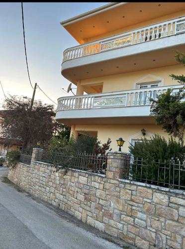 a building with a stone wall and a fence at Villa Kastri in Igoumenitsa