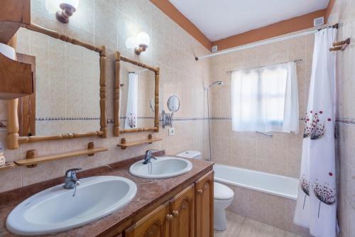 a bathroom with two sinks and a tub and a toilet at Apartamento B Armonia Rural in Granadilla de Abona