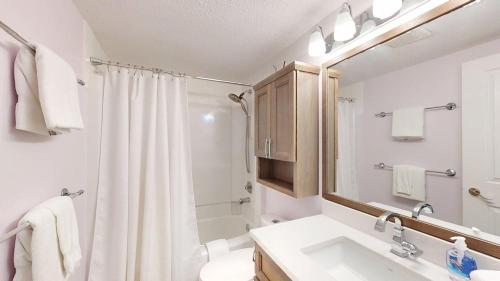a white bathroom with a sink and a shower at Snow Ghost Inn 220 by Okanagan Premier in Big White