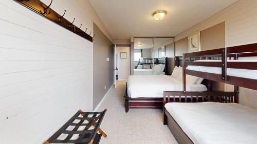 a bedroom with two bunk beds and a staircase at Snow Ghost Inn 220 by Okanagan Premier in Big White