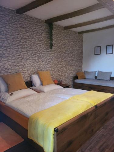 two beds in a room with a brick wall at BODZA Apartment in Tompa