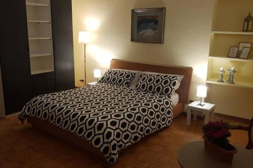 a bedroom with a bed with a black and white comforter at Casa della Ludo Biella in Biella
