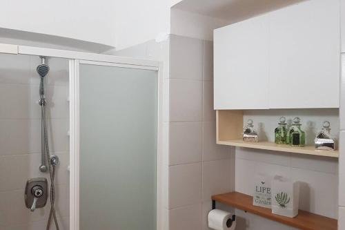 a bathroom with a shower and a white cabinet at Casa della Ludo Biella in Biella