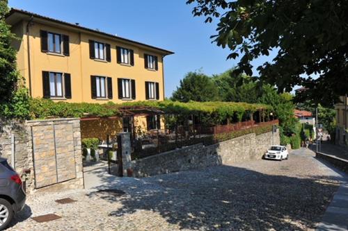 a house with a car parked in front of it at Le Funi Hotel in Bergamo