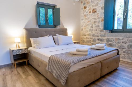 a bedroom with a large bed with towels on it at Mainotti's house with balcony in Areopoli
