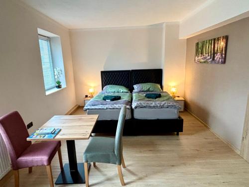 a bedroom with a bed and a table and a dining room at kERVANHOF an der Donau in Kleinpöchlarn