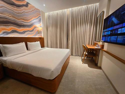 a bedroom with a bed and a desk and a television at Krishna Palace Hotel , Ulhasnagar in Ulhāsnagar