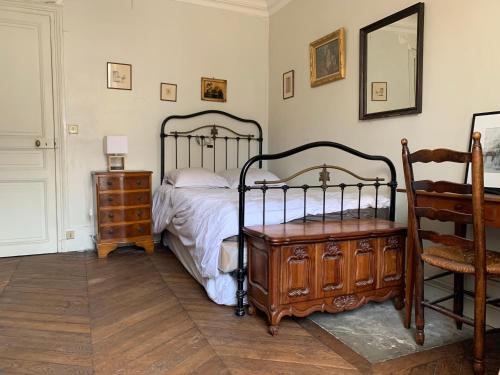 a bedroom with a bed and a dresser and a chair at Chambre à Montmartre in Paris