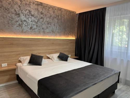 a bedroom with a large bed with white sheets at Mangalia Cozy Suite in Mangalia