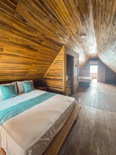 a bedroom with a large bed with a wooden ceiling at Cabaña Kokkos Del Mar in Santa Marta