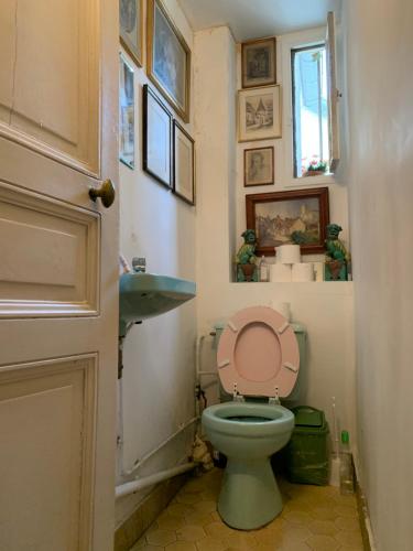 a bathroom with a toilet with a pink lid at Chambre à Montmartre in Paris