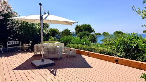 a patio with an umbrella and chairs on a deck at Villa Edo Cefalù in Cefalù