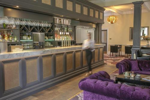a woman is standing in front of a bar at Burlington Hotel, BW Premier Collection by Best Western in Folkestone