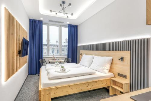 a bedroom with a bed with blue curtains at Apartmány Prusinovského in Kroměříž
