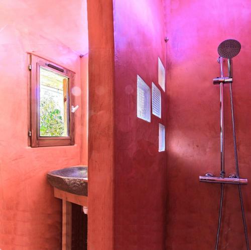 a red bathroom with a sink and a shower at House Pool Out In The Wilds in Salernes