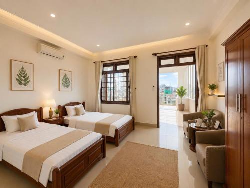 a hotel room with two beds and a couch at Hani Motel Da Nang in Danang