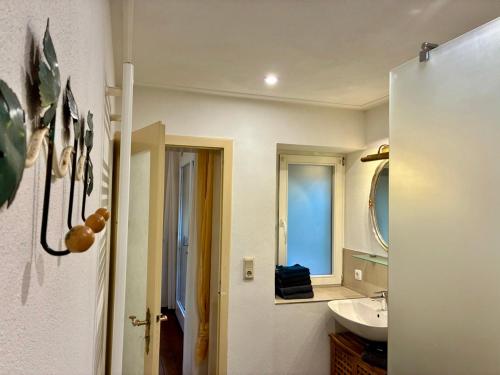 a bathroom with a sink and a mirror at Bellevue - mit Balkon und Aussicht in Maring-Noviand