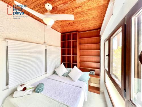 a bedroom with two beds and a ceiling fan at Pensión RENCH in Alcossebre