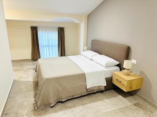 a bedroom with a large bed and a window at Tanushi Central Apartments in Vau i Dejës