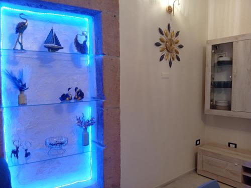 a shelf with blue lights in a room at Astrolicamus, Intero Alloggio con camera e bagno in Bosa