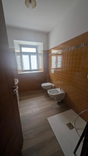 a bathroom with two toilets and a window at Appartamento al Quadrato in Lorenzago