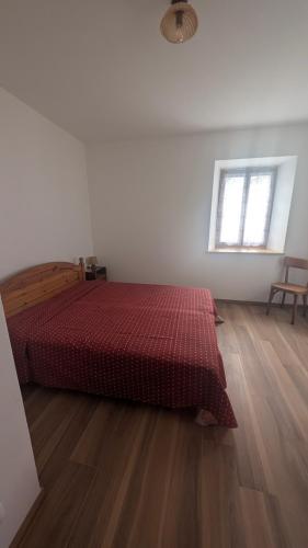 a bedroom with a bed and a wooden floor at Appartamento al Quadrato in Lorenzago