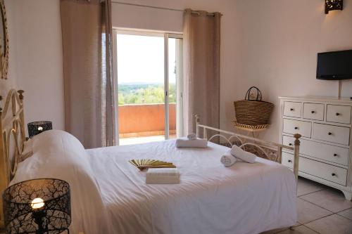 a bedroom with a white bed and a window at U Paesolu in Sainte-Lucie de Porto-Vecchio