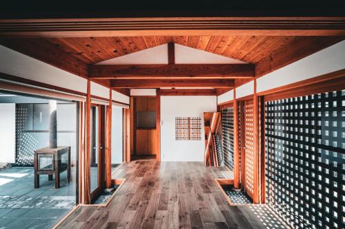 a hallway of a house with wooden flooring and glass doors at ウエダハウス in Ueda