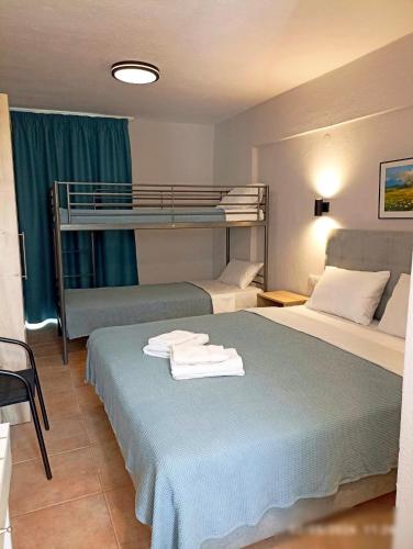 a hotel room with two beds and a bunk bed at ATHINA MARE-SOLE in Kallithea Halkidikis