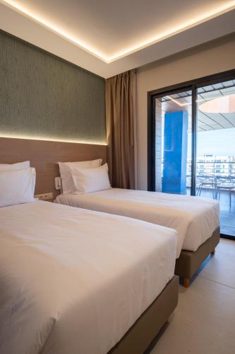 two beds in a hotel room with a balcony at Zephyr Martil in Martil