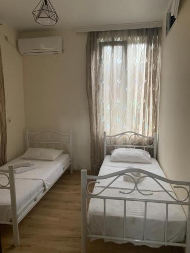 two beds in a small room with a window at LouNik Kobuleti in Kobuleti