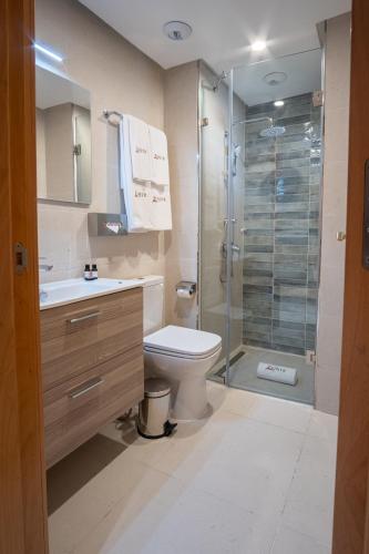 a bathroom with a toilet and a glass shower at Zephyr Martil in Martil
