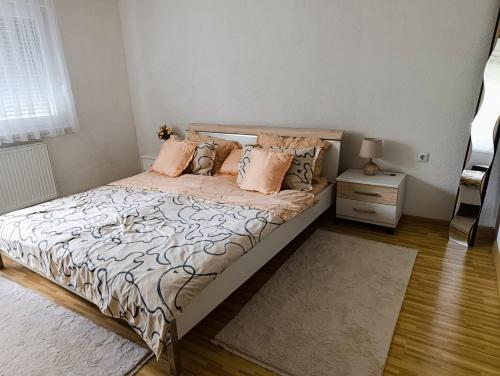 a bedroom with a bed with pink pillows at Apartmani Srebrenik in Srebrenik