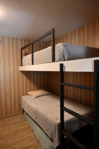 two bunk beds in a room with a bed at Chatowasi Mountain Lodge in Santa Eulalia
