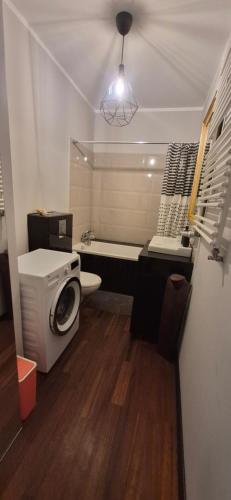 a bathroom with a washing machine and a toilet at Apartament Maciejkowa in Szczecin