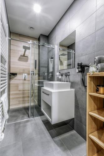 a bathroom with a white sink and a shower at Apartmány Prusinovského in Kroměříž