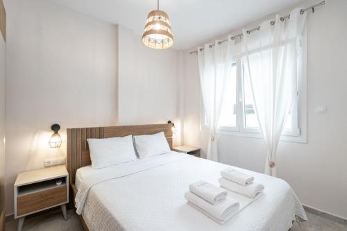 a bedroom with a white bed with towels on it at EriZen Jacuzzi suites in Keramoti
